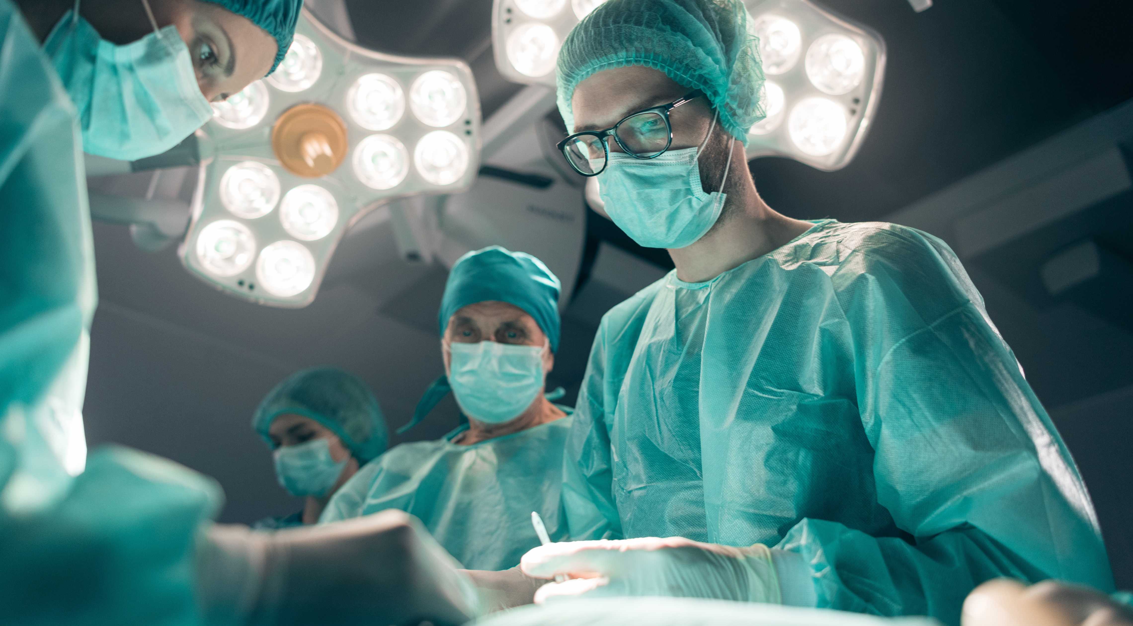 Cover van UX design case study toont chirurgen in de operatiekamer met lampen boven het hoofd.